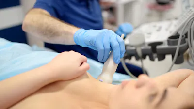 Mammologist doctor examines a woman breasts and lymph nodes using ultrasound. Mammography and ultrasound scanning are main methods of instrumental diagnosis of mammary glands. Breast cancer awareness