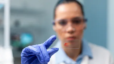 Biologist scientist holding glass with blood sample working at microbiology experiment in biochemistry hospital laboratory. Scientist woman doctor developing healthcare treatment against virus disease